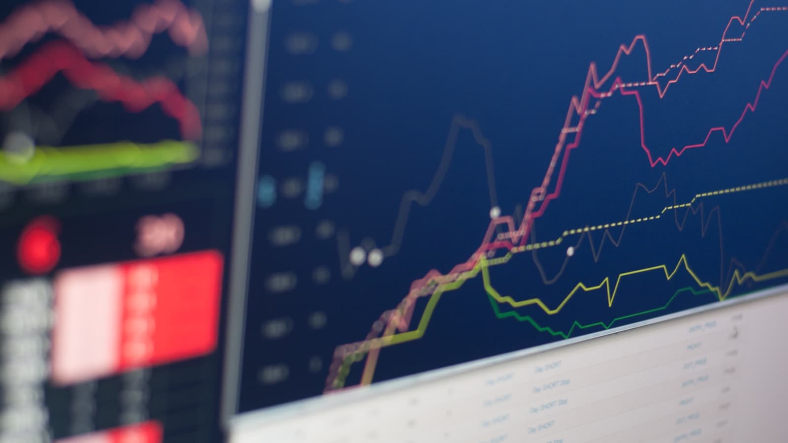Rising multi-line performance charts displayed on a dark screen